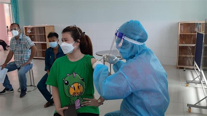 Người dân phường "vùng xanh" Tương Bình Hiệp, thành phố Thủ Dầu Một, tỉnh Bình Dương tiêm vaccine phòng COVID-19. (Ảnh: Chí Tưởng/TTXVN) Bình Dương: Số ca xuất viện hàng ngày thường cao hơn số ca nhập viện ảnh 1