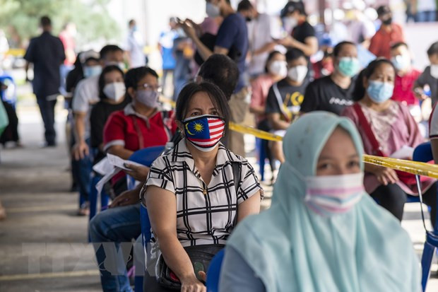 Người dân xếp hàng chờ tiêm vaccine phòng COVID-19 tại Selongor, Malaysia. (Ảnh: THX/TTXVN) Các quốc gia Đông Nam Á và chiến lược "sống chung" với COVID-19 ảnh 2
