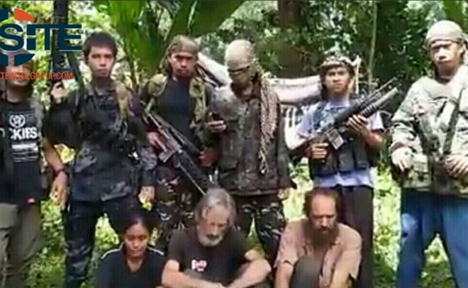 Phiến quân Abu Sayyaf và những con tin bị chúng bắt cóc. (Nguồn: TTXVN) Philippines-Malaysia-Indonesia hợp tác chống phiến quân Abu Sayyaf ảnh 1