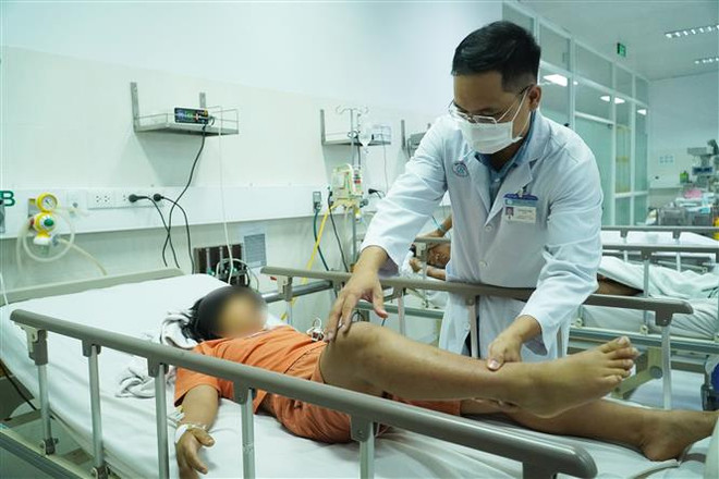 Bác sỹ Bệnh viện Chợ Rẫy thăm khám cho bệnh nhi ngộ độc Botulinum. (Ảnh: TTXVN phát) TP.HCM: 3 anh em ruột nghi ngộ độc Botulinum sau khi ăn giò bán dạo ảnh 1