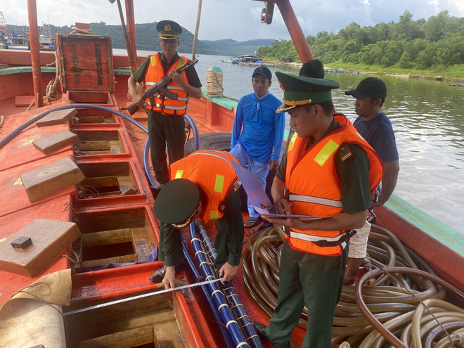 Cán bộ Đồn Biên phòng cửa khẩu Cảng An Thới đo khối lượng dầu trên tàu vận chuyển trái phép. (Ảnh: TTXVN phát) Chặn bắt 2 tàu vận chuyển gần 120.000 lít dầu DO không rõ nguồn gốc ảnh 1