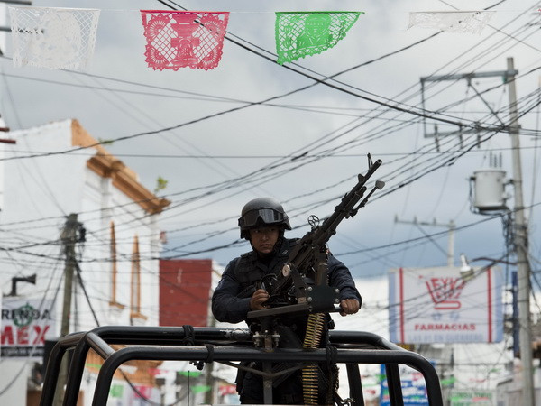 Cảnh sát liên bang gác trên một đường phố ở Teloloapan, bang Guerrero ngày 19/10. (Nguồn: AFP/TTXVN) Thống đốc bang ở Mexico xin từ chức do vụ 43 người mất tích ảnh 1