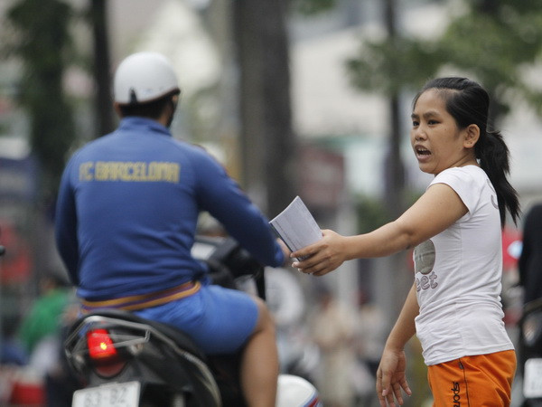 Người hâm mộ phớt lờ lời chào bán vé của một bé gái. (Ảnh: Minh Chiến/Vietnam+) Tuyển U19 Việt Nam thất bại, giá vé rớt thảm hại ảnh 1
