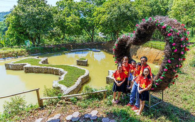 Nhiều gia đình cùng nhau mặc áo cờ đỏ sao vàng đến checkin cùng với bản đồ Việt Nam được xây từ 350.000 viên đá cuội để giáo dục các con lòng yêu nước. (Ảnh: Nguyễn Quốc/Vietnam+) Độc đáo hình bản đồ Việt Nam được gắn kết từ 350.000 viên đá cuội ảnh 7