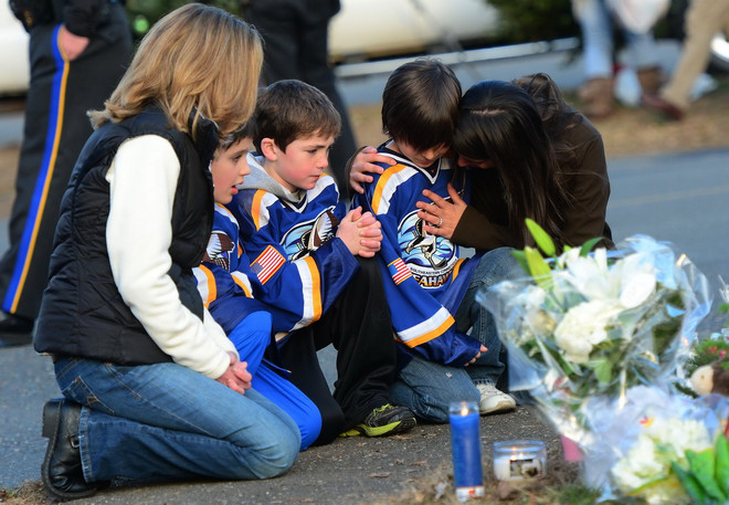 Trẻ em cùng gia đình tưởng niệm các nạn nhân tại Sandy Hook. (Nguồn: AFP/TTXVN) Mỹ: Gia đình nạn nhân vụ thảm sát kiện công ty chế tạo súng ảnh 1