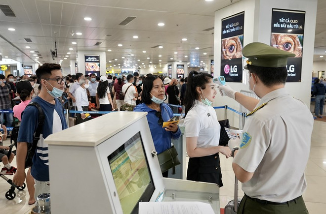 Kiểm tra thông tin cá nhân của hành khách và đo thân nhiệt trước khi vào điểm soi chiếu. (Ảnh: CTV/Vietnam+) Hàng không áp dụng kiểm soát an ninh cấp độ 1 trong thời gian bầu cử ảnh 1