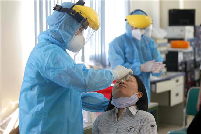 Thực hiện xét nghiệm sàng lọc COVID-19 ngẫu nhiên cho công nhân Công ty TNHH Kim May Organ Việt Nam. (Ảnh: Thanh Vũ/TTXVN) Tiếp tục nâng cao mức độ cảnh giác, chủ động kiểm soát dịch COVID-19 ảnh 1