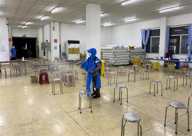 Các nhân viên y tế phun khử khuẩn sau mỗi đợt lấy mẫu xét nghiệm sàng lọc COVID-19 ngẫu nhiên. (Ảnh: Thanh Vũ/TTXVN) Tiếp tục nâng cao mức độ cảnh giác, chủ động kiểm soát dịch COVID-19 ảnh 2