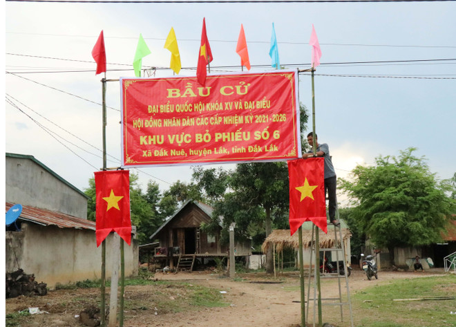 Người dân xã Đắk Nuê, huyện Lắk trang trí khu vực bỏ phiếu chào mừng Ngày hội non sông. (Ảnh: Anh Dũng/TTXVN) Lá phiếu gửi gắm niềm tin và trách nhiệm của cử tri Đắk Lắk ảnh 1