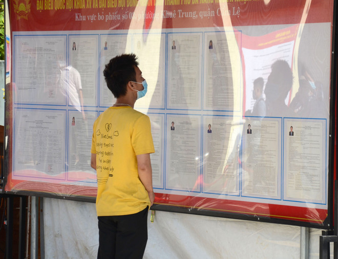 Cử tri nghiên cứu thông tin các ứng cử viên. (Ảnh: Quốc Dũng/TTXVN) Bầu cử Quốc hội: Cử tri Đà Nẵng chờ đón Ngày hội non sông ảnh 2