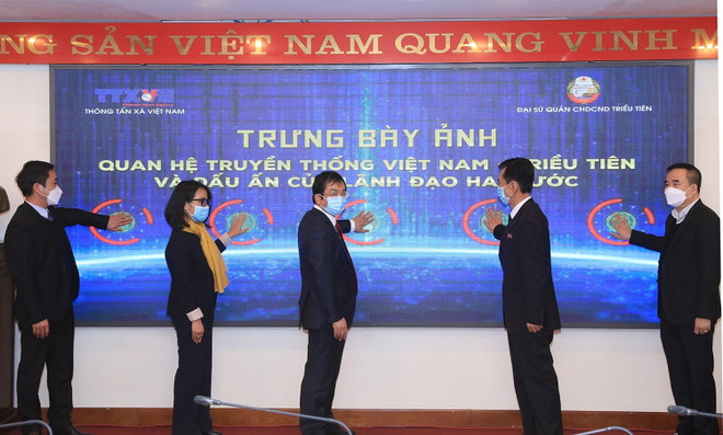 Phó Tổng giám đốc Thông tấn xã Việt Nam Nguyễn Tuấn Hùng và Tham tán, Đại biện lâm thời Đại sứ quán Cộng hòa dân chủ nhân dân Triều Tiên tại Việt Nam Ri Ho Jun cùng các đại biểu bấm nút khai mạc trưng bày ảnh. (Ảnh: Tuấn Anh/TTXVN) Khai mạc trưng bày ảnh “Quan hệ truyền thống Việt Nam-Triều Tiên" ảnh 1