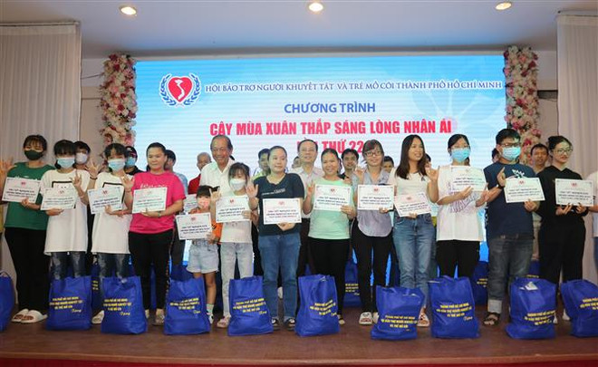 Nguyên Phó Thủ tướng thường trực Chính phủ Trương Hòa Bình trao quà cho người khuyết tật và trẻ em mồ côi thành phố tại chương trình “Cây mùa Xuân thắp sáng lòng nhân ái lần thứ 22”. (Ảnh: Thanh Vũ/TTXVN) Ấm lòng những hoạt động hỗ trợ người nghèo dịp Tết Nguyên đán ảnh 2