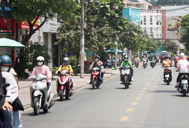 Người dân lưu thông bằng xe gắn máy trưa ngày 27/4/2023 trên đường Hoàng Diệu, thành phố Thủ Đức. Ảnh: Hồng Đạt - TTXVN ttxvn-nang-nong-thu-duc-3839.jpg