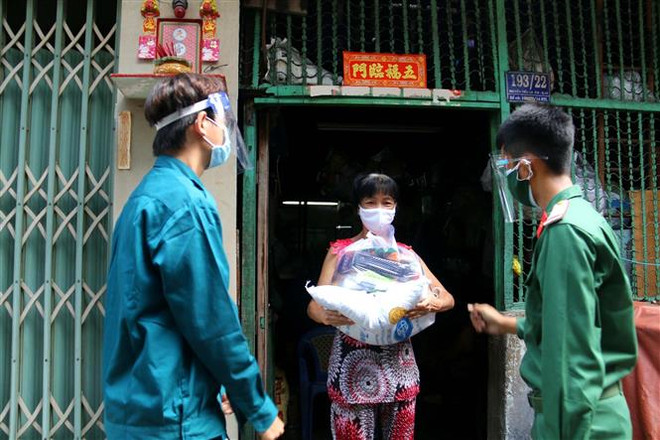 Các chiến sỹ Trung đoàn 88, Sư đoàn 302 (Quân Khu 7) cùng với Ban Chỉ huy quân sự phường 8, Quận 10 trao tặng lượng thực, thực phẩm tận nhà cho người lao động nghèo hẻm 139 Nguyễn Tiểu La, Quận 10. (Ảnh: Thanh Vũ /TTXVN) TP.Hồ Chí Minh: Mở rộng đối tượng được hưởng gói hỗ trợ an sinh xã hội ảnh 1