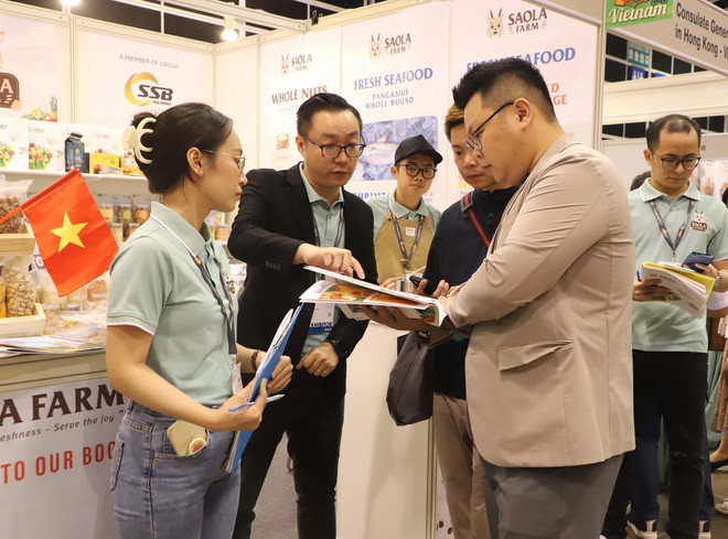 Khách hàng quốc tế tìm hiểu về các sản phẩm nổi tiếng của Việt Nam. (Ảnh: Xuân Vịnh/TTXVN) ttxvn_hoi cho am thuc hong kong (3).jpg