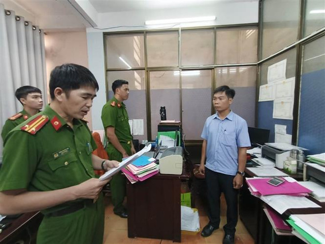 Công an tỉnh Quảng Ngãi đọc Quyết định khởi tố Bùi Mạnh Tường (sinh năm 1973), nhân viên Văn phòng đăng ký đất đai tỉnh Chi nhánh thành phố Quảng Ngãi. (Ảnh: TTXVN) Quảng Ngãi: Khởi tố 3 cán bộ thuộc Văn phòng đăng ký đất đai tỉnh ảnh 1