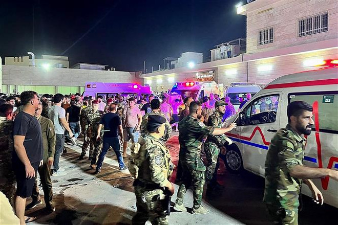 Binh sỹ và lực lượng phản ứng nhanh Iraq chuyển các nạn nhân vụ hỏa hoạn trong đám cưới tới bệnh viện Hamdaniyah ở Al-Hamdaniyah, Iraq ngày 27/9/2023. (Ảnh: AFP/TTXVN) Iraq: Hé lộ nguyên nhân gây hỏa hoạn tại đám cưới khiến 114 người chết ảnh 1