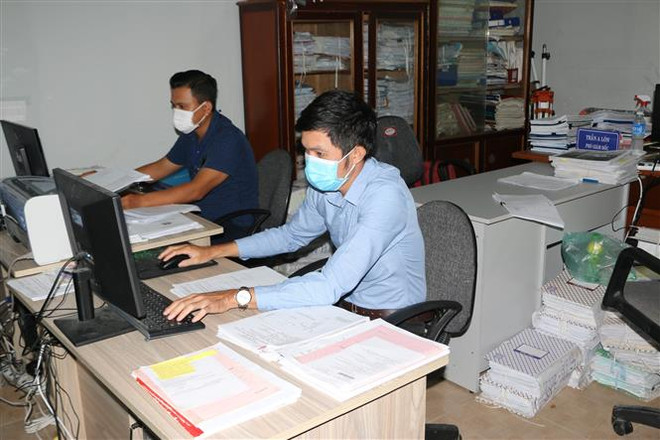 Cán bộ Văn phòng đăng ký đất đai thành phố Bạc Liêu thực hiện các biện pháp nghiệp vụ trong việc cấp giấy chứng nhận quyền sử dụng đất. (Ảnh: Tuấn Kiệt/TTXVN) Tạo đột phá từ cải cách: Giám sát để giảm chi phí không chính thức ảnh 1