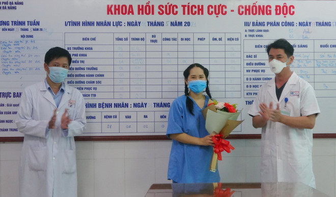 Lãnh đạo Bệnh viện Đà Nẵng trao hoa chúc mừng bệnh nhân. (Ảnh: TTXVN) Nữ điều dưỡng bị sốc phản vệ sau tiêm vaccine COVID-19 đã xuất viện ảnh 1