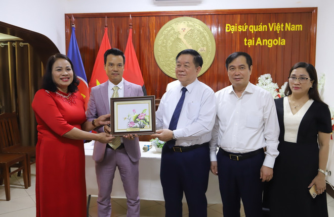 Trưởng ban Tuyên giáo Trung ương Nguyễn Trọng Nghĩa tặng quà lưu niệm cho đại diện cộng đồng người Việt Nam tại Angola. (Ảnh: Hồng Minh/TTXVN) ttxvn_nguyen trong nghia angola (1).jpg