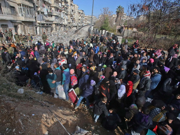 Những người dân Syria, từng phải sơ tán để tránh các cuộc giao tranh, tập trung tại điểm kiểm soát ở Maysaloun - khu vực lân cận với Aleppo ngày 8/12. (Nguồn: AFP/TTXVN) Nga tuyên bố giúp hơn 8.000 dân thường rời khỏi Aleppo ảnh 1