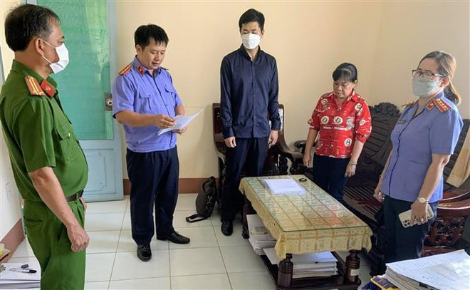 Cơ quan điều tra Viện Kiểm sát nhân dân Tối cao tống đạt Quyết định khởi tố bị can đối với bị can Nguyễn Thị Ngọc Tuyền (áo đỏ), nguyên thủ quỹ Chi cục Thi hành án dân sự huyện Thới Lai, thành phố Cần Thơ. (Ảnh: TTXVN phát) Thi hành án dân sự: Rút ngắn thời gian, giảm thiểu chi phí ảnh 1