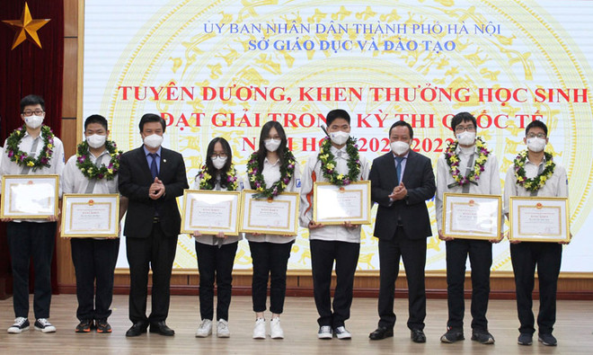 Thứ trưởng Bộ Giáo dục và Đào tạo Nguyễn Hữu Độ và Phó Bí thư Thành ủy Hà Nội Nguyễn Văn Phong trao Bằng khen của Ủy ban Nhân dân thành phố cho các học sinh đạt Huy chương Vàng. (Nguồn: Báo Hà Nội mới) Thành phố Hà Nội tuyên dương học sinh đoạt giải các kỳ thi quốc tế ảnh 1
