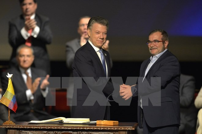 Tổng thống Colombia Juan Manuel Santos (trái) và thủ lĩnh tối cao FARC Timoleon Jimenez. (Nguồn: AFP/TTXVN) Tôn vinh nỗ lực kiến tạo hòa bình của Chính phủ Colombia và FARC ảnh 1