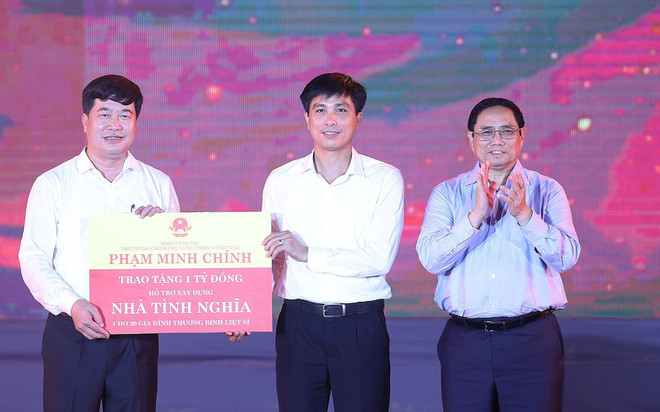 Thủ tướng Phạm Minh Chính trao cho đại diện huyện Anh Sơn kinh phí hỗ trợ xây dựng nhà tình nghĩa cho 20 gia đình thương binh, liệt sỹ. (Ảnh: Dương Giang/TTXVN) Thủ tướng dự Chương trình nghệ thuật “Bản hùng ca bất diệt” ảnh 1