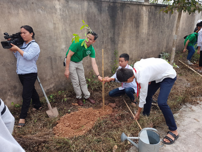 Đại diện trường Đại học Lâm nghiệp và các em học sinh trồng cây xanh trong khuôn viên trường Trung học phổ thông Lưu Hoàng, huyện Ứng Hòa. (Ảnh: Hùng Võ/Vietnam+) Hà Nội sẽ có thêm 4.000 cây xanh để giảm thiểu ô nhiễm không khí ảnh 2