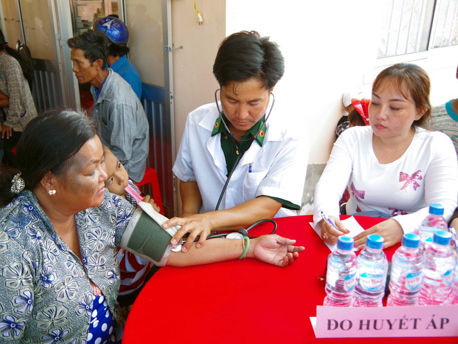 Người “thầy thuốc Quân hàm xanh” Lê Văn Quốc khám bệnh cho bà con Khmer nghèo khu vực biên giới biển xã Vĩnh Hải, thị xã Vĩnh Châu, tỉnh Sóc Trăng. (Ảnh: Trung Hiếu-Văn Long/TTXVN) Người thầy thuốc quân hàm xanh hết lòng vì người nghèo vùng biên giới ảnh 1