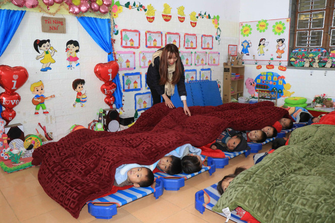 Giáo viên Trường Mầm no Tà Xùa, huyện Bắc Yên đắp thêm chăn cho học sinh vào những ngày nhiệt độ xuống thấp. (Ảnh: Hữu Quyết/TTXVN) Phấn đấu đến năm 2030 xóa bỏ 100% phòng học nhờ, phòng học tạm ảnh 2