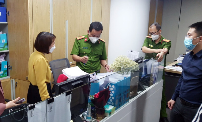 Lực lượng chức năng khám xét và thu giữ tài liệu tại trụ sở FLC. (Ảnh: Phạm Kiên/TTXVN) Vụ Trịnh Văn Quyết thao túng chứng khoán: Khởi tố thêm 15 bị can ảnh 1