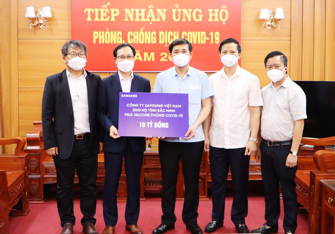 Ông Choi Joo Ho, Tổng Giám đốc Tổ hợp Samsung Việt Nam (thứ 2 từ trái sang) trao hỗ trợ ủng hộ công tác phòng, chống dịch COVID-19 tại tỉnh Bắc Ninh. (Ảnh: Đinh Văn Nhiều/TTXVN) Samsung Việt Nam hỗ trợ Bắc Ninh 10 tỷ đồng phòng, chống dịch COVID-19 ảnh 1