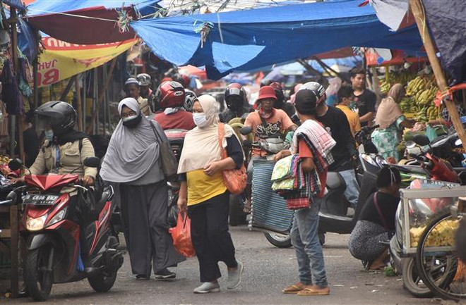 Người dân mua sắm tại một khu chợ ở Bekasi, Indonesia. (Ảnh: AFP/TTXVN) Kinh tế Indonesia tăng trưởng vượt dự báo trong quý 3 ảnh 1