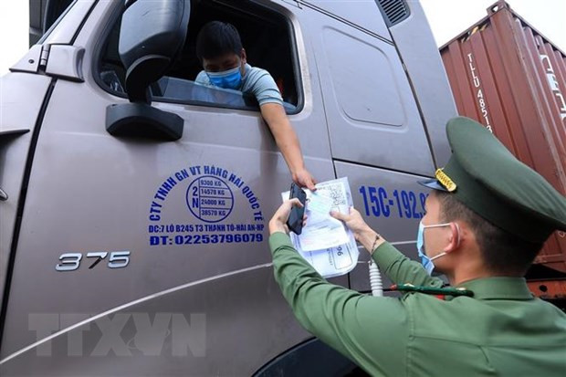 Lực lượng chức năng tại chốt kiểm dịch đầu cầu Trung Hà, huyện Ba Vì kiểm tra giấy thông hành và thẻ “luồng xanh” của các phương tiện vận tải ra, vào thành phố tháng 8/2021. (Ảnh: Tuấn Anh/TTXVN) Hóa giải thách thức, chung sức đồng lòng vì một Việt Nam phát triển ảnh 2