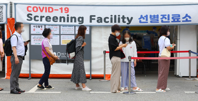 Người dân xếp hàng chờ xét nghiệm COVID-19 tại Seoul, Hàn Quốc. (Ảnh: THX/TTXVN) Dịch COVID-19 tiếp tục diễn biến phức tạp tại Hàn Quốc, Ấn Độ ảnh 1