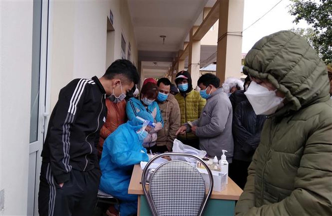 Công nhân chen nhau lấy mẫu xét nghiệm tại Trạm y tế phường Bình Minh, thị xã Nghi Sơn (Thanh Hóa). (Ảnh: Nguyễn Nam/TTXVN) Thanh Hóa: Chấn chỉnh công tác xét nghiệm COVID-19 tại thị xã Nghi Sơn ảnh 1