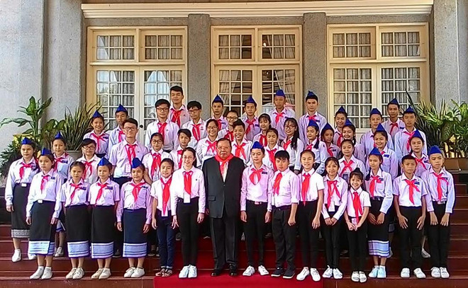 Tổng Bí thư, Chủ tịch nước Lào Bounnhang Volachith chụp ảnh chung với 20 thiếu nhi tiêu biểu của Việt Nam. (Ảnh: Phạm Kiên/Vietnam+) Giới trẻ Việt-Lào cần cùng chung lòng vun đắp quan hệ song phương ảnh 2