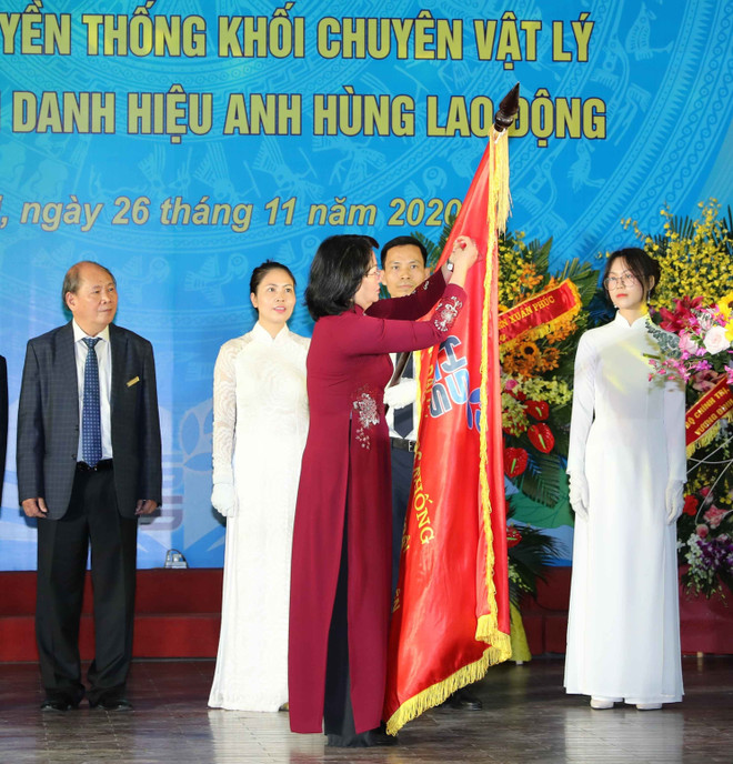 Phó Chủ tịch nước Đặng Thị Ngọc Thịnh gắn Danh hiệu Anh hùng Lao động lên lá cờ truyền thống của trường THPT Chuyên Khoa học tự nhiên. (Ảnh: Thanh Tùng/TTXVN) Trường THPT Chuyên Khoa học Tự nhiên đón nhận danh hiệu Anh hùng ảnh 1