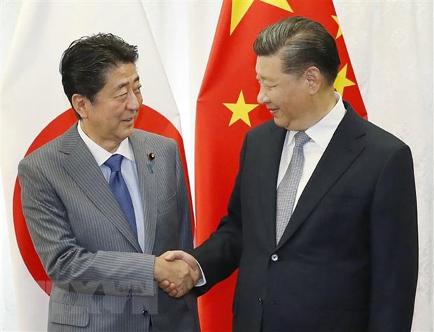 Chủ tịch Trung Quốc Tập Cận Bình (phải) và Thủ tướng Nhật Bản Shinzo Abe (trái) trong cuộc gặp bên lề Diễn đàn Kinh tế phương Đông (EEF) lần thứ 4 tại Vladivostok, Nga ngày 12/9/2018. (Ảnh: AFP/TTXVN) Dịch COVID-19 làm hỏng chính sách đối ngoại của Nhật Bản ảnh 1
