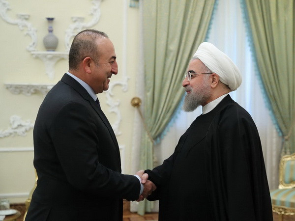 Tổng thống Iran Hassan Rouhani (phải) có cuộc gặp với Ngoại trưởng Thổ Nhĩ Kỳ Mevlut Cavusoglu đang trong chuyến thăm Iran. (Nguồn: EPA/TTXVN) Iran muốn hợp tác với Thổ Nhĩ Kỳ giải quyết vấn đề Iraq và Syria ảnh 1