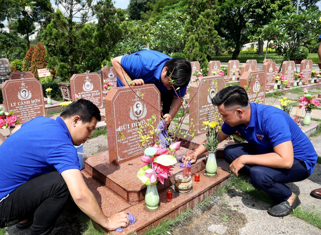 Đoàn viên Cơ quan TTXVN khu vực phía Nam chăm sóc phần mộ Anh hùng liệt sỹ-nhà báo Bùi Đình Túy, nguyên Phó Giám đốc Thông tấn xã Giải phóng. (Ảnh: Hồng Đạt/TTXVN) Tuổi trẻ Thông tấn xã Việt Nam với hành trình về địa chỉ đỏ ảnh 2