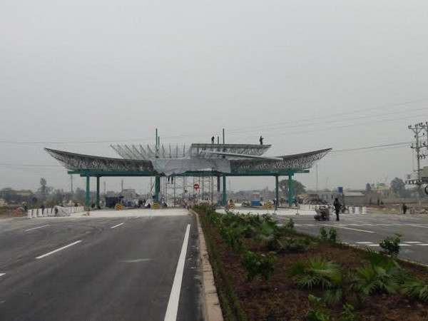 Các công nhân đang gấp rút hoàn thiện công việc lắp đặt, hoàn thiện trạm thu phí. (Ảnh: Nguyễn Trường/TTXVN) Ngày 11/1 thông xe tuyến đường bộ đoạn Phủ Lý-Mỹ Lộc ảnh 1