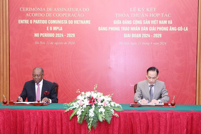Ông Lê Hoài Trung và ông Manuel Domingos Augusto ký kết hợp tác giữa hai Đảng. (Ảnh: Phương Hoa/TTXVN) ttxvn_dang_cong_san_viet_nam_va_dang_phong_trao_nhan_dan_giai_phong_angola_tang_cuong_hop_tac_2108.jpg