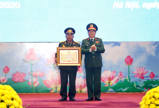 Đại tướng Ngô Xuân Lịch, Uỷ viên Bộ Chính trị, Phó Bí thư Quân uỷ Trung ương, Bộ trưởng Bộ Quốc phòng trao Huân chương Độc lập hạng Nhất cho Đại tướng Chansamone Chanyalath, Bộ trưởng Bộ Quốc phòng CHDCND Lào. (Ảnh: Dương Giang/TTXVN) Trao Huân chương của Nhà nước Việt Nam và Lào cho các tập thể, cá nhân ảnh 1