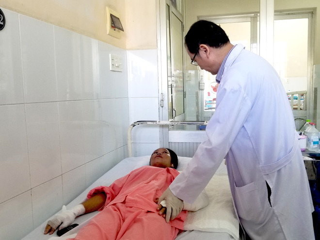 Tiến sỹ, bác sỹ Ngô Đức Hiệp, Trưởng Khoa Phỏng-Phẫu thuật tạo hình khám cho một sản phụ sau sinh bị bỏng do sưởi than. (Ảnh: Đinh Hằng/TTXVN) Cảnh báo nguy hiểm từ việc sười ấm bằng than với phụ nữ sau sinh ảnh 1