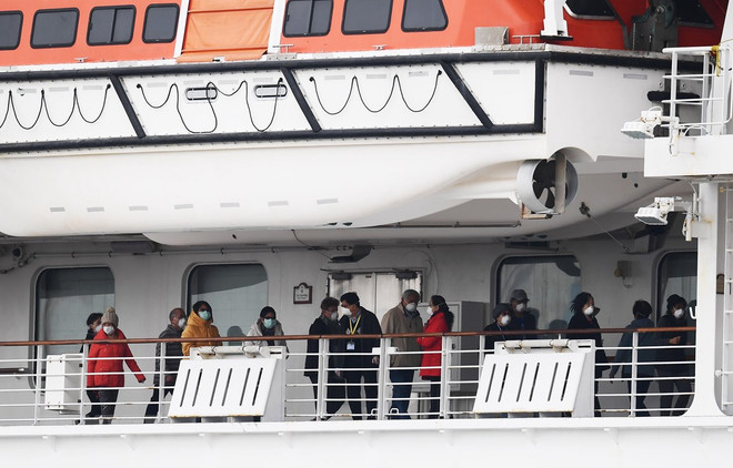 Các hành khách trên tàu du lịch Diamond Princess tại khu vực cách ly cảng Yokohama, Nhật Bản, ngày 14/2. (Ảnh: AFP/TTXVN) Nhật Bản thử nghiệm dùng thuốc HIV điều trị người nhiễm COVID-19 ảnh 1