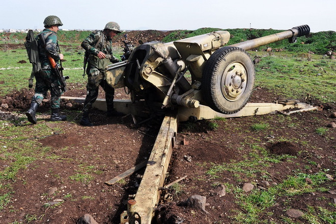 Binh sỹ Chính phủ Syria kiểm tra các khẩu đội pháo đặt tại khu vực giữa Talbiseh và Rastan ở ngoại ô thành phố Homs, Syria ngày 1/3. (Nguồn: AFP/TTXVN) Quân đội Syria tiến về phía Nam thủ đô sau khi giải phóng Douma ảnh 1