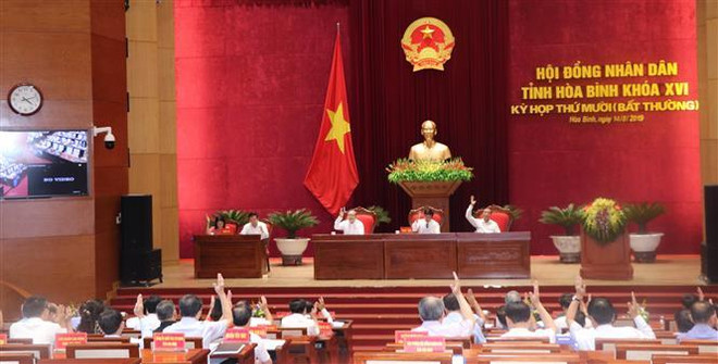 Các đại biểu HĐND tỉnh Hòa Bình biểu quyết thông qua các Nghị quyết tại kỳ họp. (Ảnh: Nhan Sinh/TTXVN) Sáp nhập toàn bộ huyện Kỳ Sơn vào thành phố Hòa Bình ảnh 1